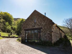 a small stone building with a large window on a dirt road at The Cottage in Middlesbrough