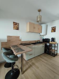 a kitchen with a wooden table and a counter at La Mansarde étoilée in Saint-Marcellin