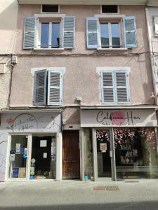 a store on a street with windows and a building at La Mansarde étoilée in Saint-Marcellin +4 photos
