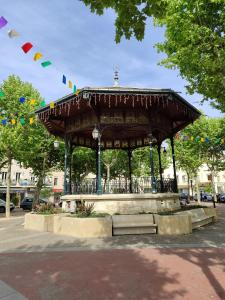 a wooden pavilion with a bench in a park at La Mansarde étoilée in Saint-Marcellin