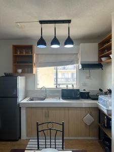 a kitchen with a sink and a refrigerator at A cozy modern design Unit 6425 in Cebu City
