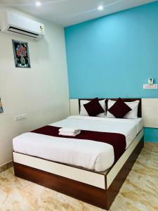a bedroom with a bed with a blue wall at S K Comforts in Bangalore