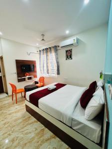a bedroom with a large bed and a living room at S K Comforts in Bangalore