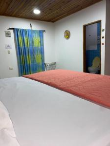 a bedroom with a bed with a red comforter at Hotel Cabo Royal in Cabo de la Vela