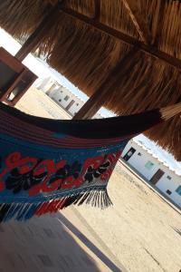 a hammock hanging from a thatched roof at Hotel Cabo Royal in Cabo de la Vela