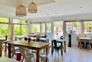 a dining room with tables and chairs and windows at KELMAN Hotel in Perito Moreno