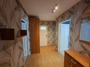 an empty room with a hallway with a tv at Apartament w Centrum III in Ustka