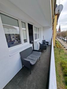 a balcony with two chairs and a window at Apartament w Centrum III in Ustka