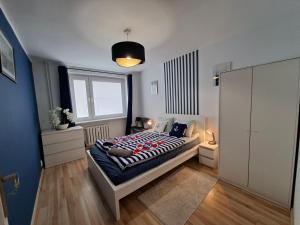 a bedroom with a bed and a large window at Apartament w Centrum III in Ustka
