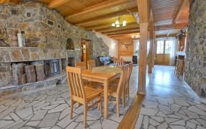 a dining room with a table and a stone wall at Pokoje Gościnne u Laskowskich in Smerek