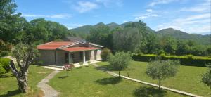 a house with a garden and mountains in the background at Rustic Cottage Montenegro Bridje in Podgorica