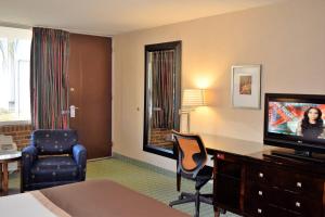 une chambre d'hôtel avec télévision, bureau et chaise dans l'établissement Landmark Inn, à Hartsville