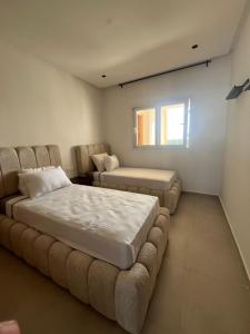 a bedroom with a bed and a couch and a window at Appartement mirador golf 3 in Cabo Negro +32 photos