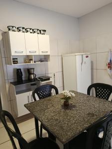 a kitchen with a table with chairs and a refrigerator at Casa de clecia in Natal