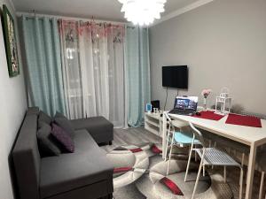 a living room with a couch and a desk with a laptop at InCentrum Pańska 3 in Warsaw
