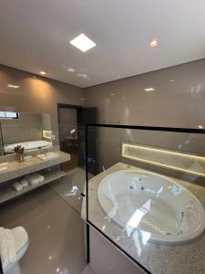 a large bathroom with a tub and a toilet at Hotel Bonfim in Silvânia +32 photos