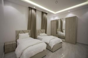 a bedroom with two beds and a mirror at فيلا ابو بندر in Jeddah +34 photos