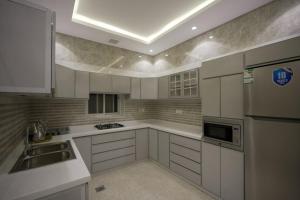 a kitchen with white cabinets and a sink at فيلا ابو بندر in Jeddah