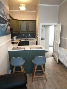 a kitchen with a counter and two stools in it at Buckie Central 2 bed Retreat 24 high street in Buckie