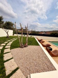 a garden with two trees and a swimming pool at Refúgio D'Aldeia in Leiria