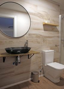 a bathroom with a sink and a toilet and a mirror at Casa Rural Garcés in Lumbier +7 photos