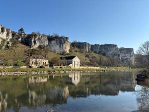 a house on the side of a river with mountains at Le Balcon d'Arcyate in Arcy-sur-Cure