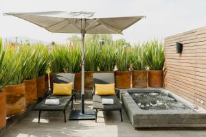a patio with two chairs and an umbrella at Dos Casas Hotel & Spa in San Miguel de Allende
