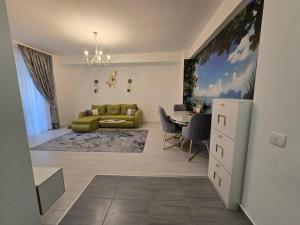 a living room with a green couch and a table at DeLux Apartment -Militari Residence Rosu Chiajna in Dudu