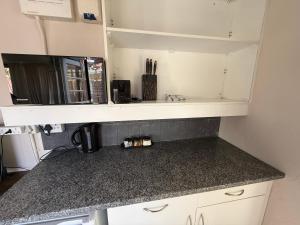 a kitchen with a counter top with a microwave at Suite Dreams Cute Studio Flat in Panorama