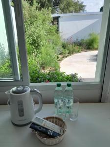 two bottles of water sitting on a counter in front of a window at Déjalo ser in Nueva Helvecia