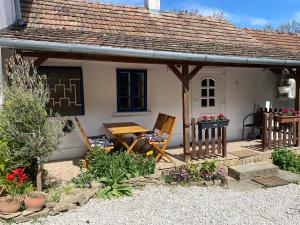 a cottage with a table and chairs in front of it at Thermal Corner Guesthouse in Alsópáhok