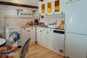 a kitchen with white cabinets and a white refrigerator at Thermal Corner Guesthouse in Alsópáhok +10 photos