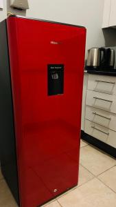a red refrigerator in the middle of a kitchen at DL Apartments in Palatswe