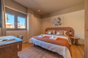 a bedroom with a large bed and a desk at Minotaur's Rest - Luxury Residences with Free Private Parking, near Port & Airport in Heraklio