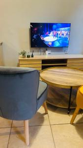 a living room with a table and a tv at DL Apartments in Palatswe