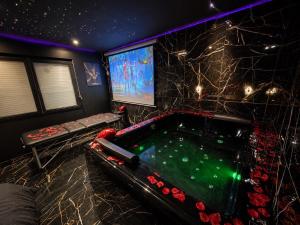 a room with a pool table and a tv at Obsidian Suite Love Room in Triel-sur-Seine
