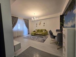 a living room with a green couch and a table at DeLux Apartment -Militari Residence Rosu Chiajna in Dudu