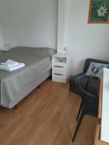 a small bedroom with a bed and a chair at Déjalo ser in Nueva Helvecia +14 photos