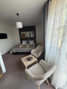 a bedroom with a bed and a chair and a table at Penzion Amfik in Mikulov