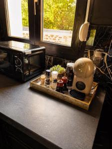 a kitchen counter with a coffee maker on a tray at Obsidian Suite Love Room in Triel-sur-Seine +6 photos