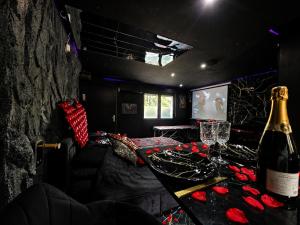 a room with a bottle of wine and roses on a table at Obsidian Suite Love Room in Triel-sur-Seine