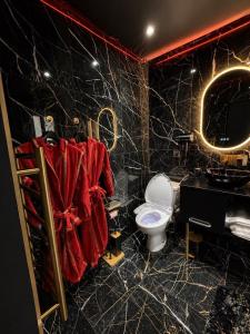 a black bathroom with a toilet and a sink at Obsidian Suite Love Room in Triel-sur-Seine