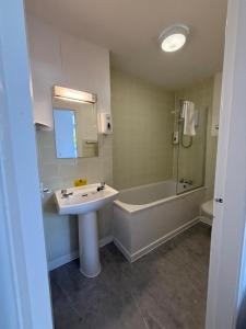 a bathroom with a sink and a bath tub and a mirror at OX Hotel Spean Bridge in Spean Bridge +60 photos