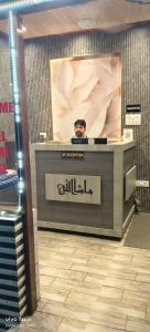 a man standing behind a counter in a store at Qasmi Hotel in Jammu