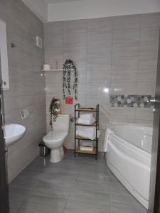 a bathroom with a tub and a toilet and a sink at DeLux Apartment -Militari Residence Rosu Chiajna in Dudu