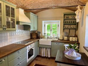 a kitchen with green cabinets and a counter top at Country Villa with Heated Pool & Private Sauna, close to South Styrian Wine Road in Kamnica