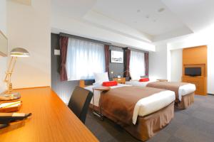 a hotel room with two beds and a desk at HOTEL MYSTAYS Kamata in Tokyo