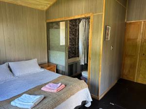 a bedroom with a bed with two towels on it at Cabañas Alelí in Chaitén