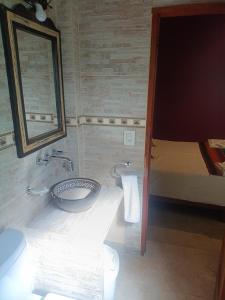 a bathroom with a sink and a mirror and a bed at Cielo Andino Colonial in Purmamarca