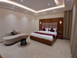 a bedroom with a large bed and a table and a couch at Vardhn Villa in Sarāhan